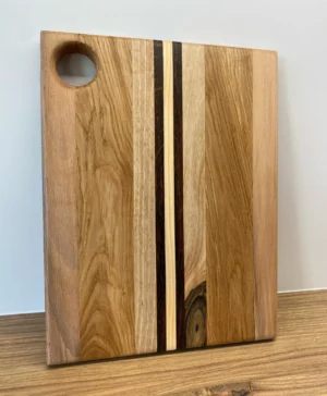 Deska do krojenia z drewnianym uchwytem, wykonana z pięciu gatunków drewna w różnorodnych kolorach.