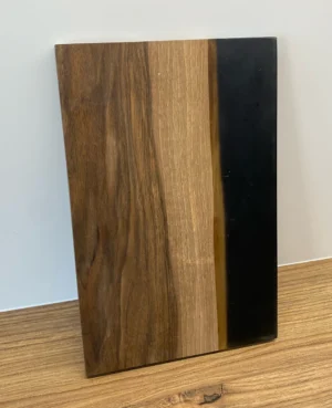 Drewniana deska do serwowania z orzecha włoskiego z czarną i brązową żywicą, elegancko wykończona.