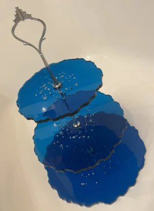 Niebieska, piętrowa patera z żywicy epoksydowej, wyposażona w srebrny uchwyt.