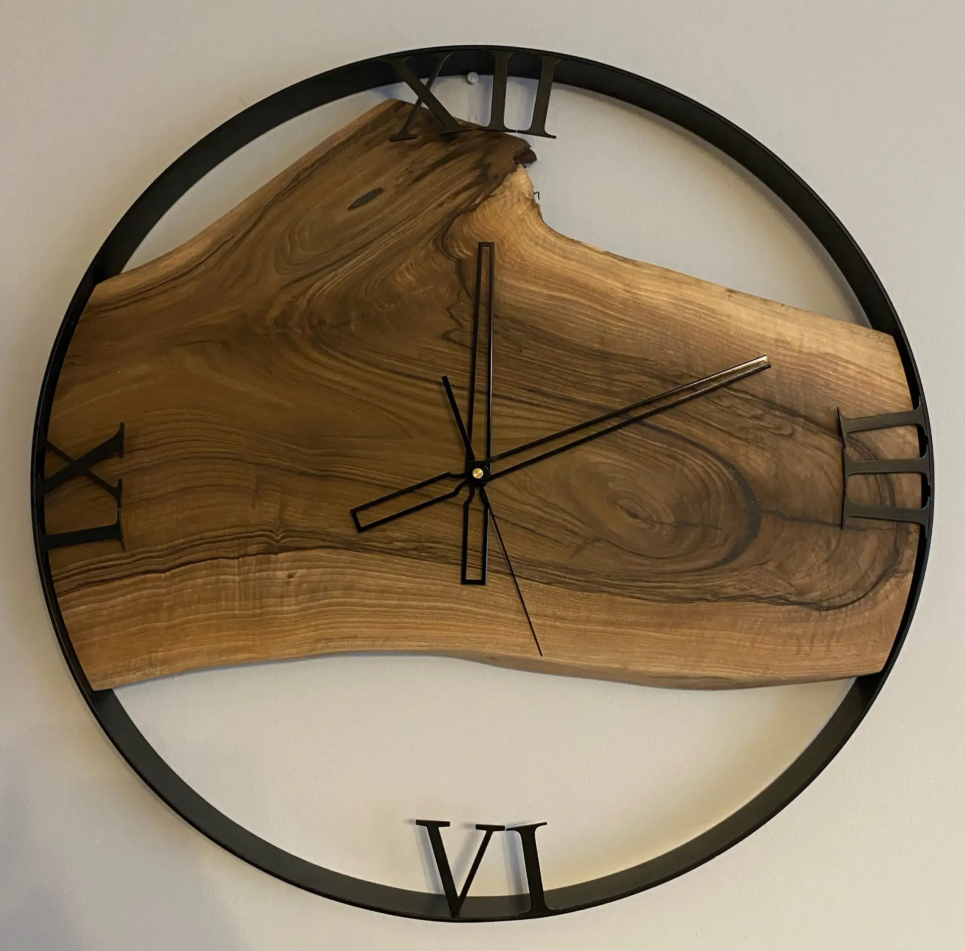 Loftowy zegar ścienny z rzymskimi cyframi, wykonany z orzecha włoskiego, w metalowej ramie, o średnicy 60 cm.