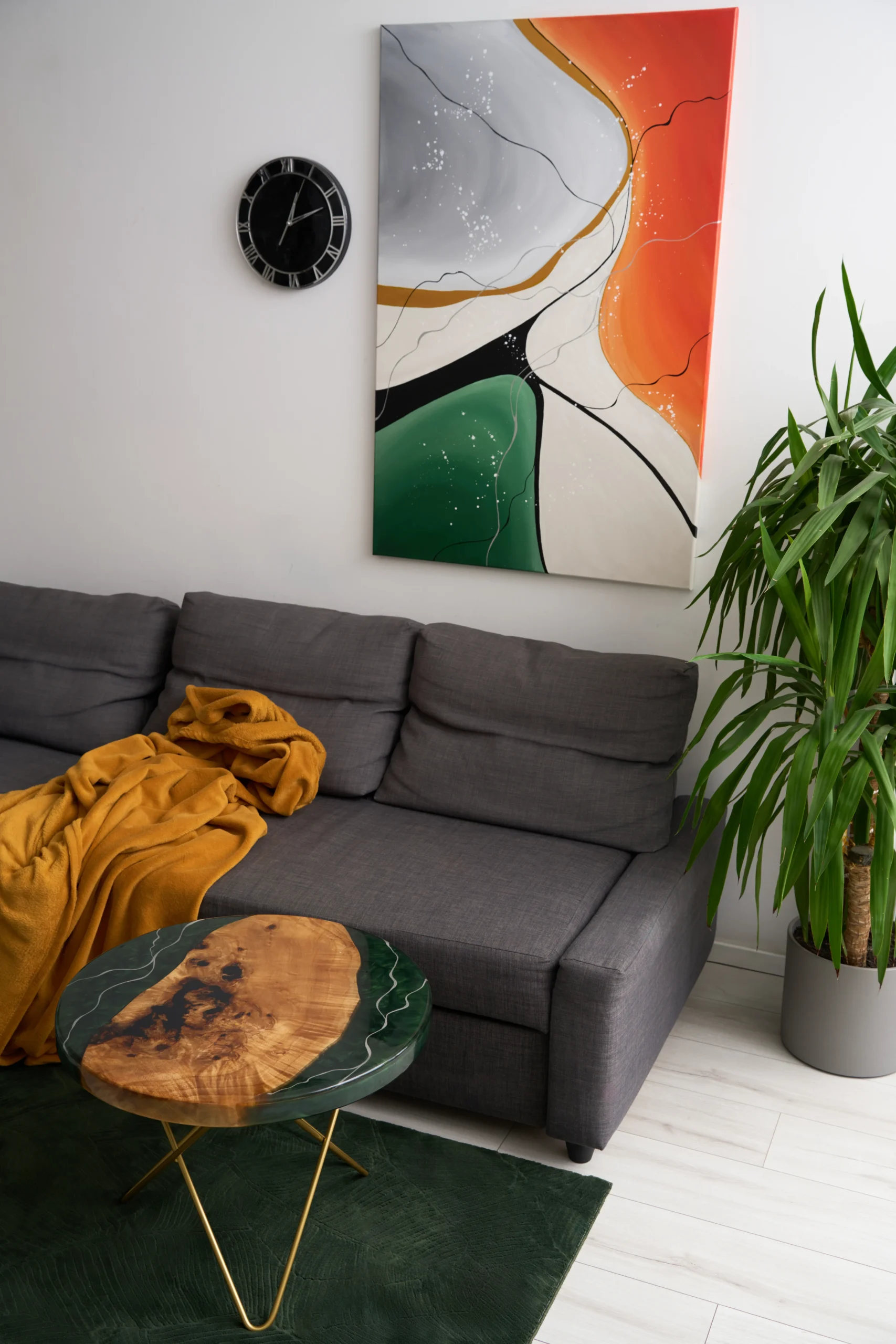 Prosty stolik kawowy oraz obraz abstrakcyjny w intensywnych barwach