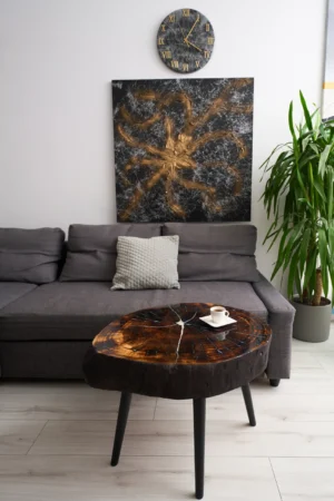 Zestaw składający się z unikalnego stolika kawowego, odważnego obrazu w czarno-złotej kolorystyce oraz zegara wykonanego z żywicy epoksydowej.